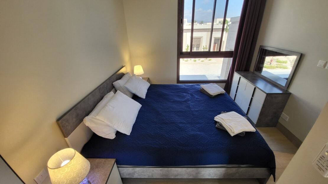 Open sleeping area with double bed in furnished studio RV26-101, Riviera, Hawana Salalah